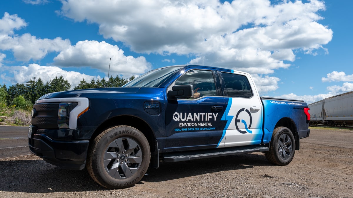 The wrapped Ford F-150 Lightning seen from the front three-quarter under a blue sky